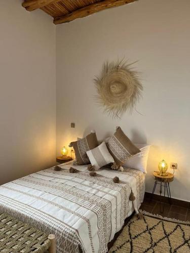 a bedroom with a bed and two tables with lamps at Le petit Chalet. in Essaouira