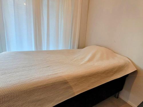 a bed in a corner of a room with a window at Loistava sijainti, perfect location. in Vantaa