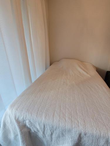 uma cama branca num quarto com uma janela em Loistava sijainti, perfect location. em Vantaa