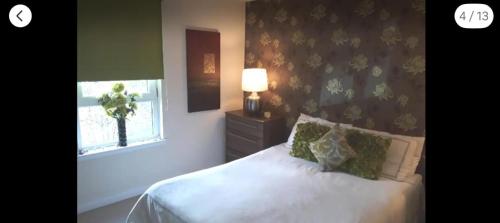 a bedroom with a white bed and a window at Spacious Modern Apartment in Glasgow