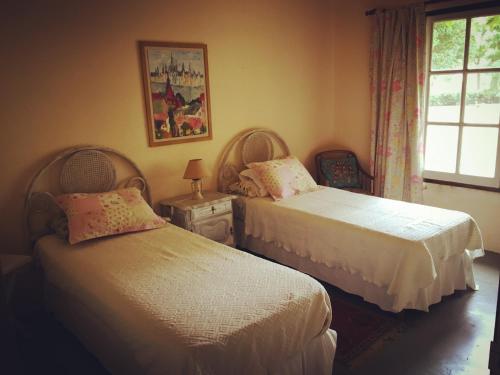 a bedroom with two beds and a window at La Madreselva in San Antonio de Areco