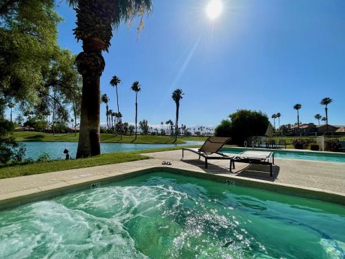 een zwembad met een bank naast een palmboom bij The View/Palm Desert Boutique Inn in Palm Desert