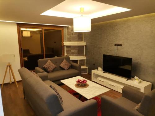 a living room with couches and a flat screen tv at زاوية سيدي عبد السلام افران in Ifrane
