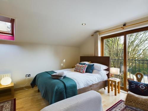 ein Schlafzimmer mit einem Bett und einem Balkon in der Unterkunft Gatelodge Studio, Ballyhackamore in Belfast