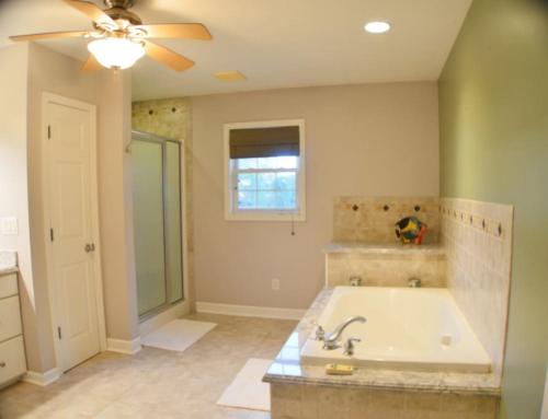 een grote badkamer met een bad en een plafondventilator bij Cozy Family Retreat with Spa Bath Fenced Yard in New Bern