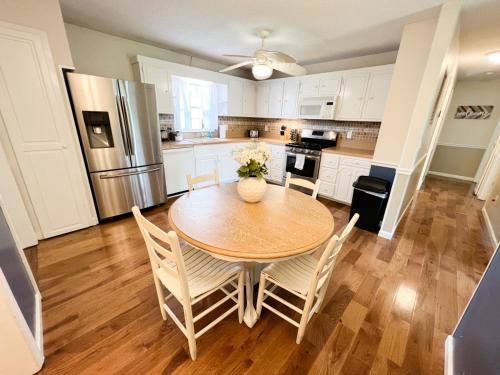 uma cozinha com uma mesa e cadeiras e um frigorífico em Cozy Family Retreat with Spa Bath Fenced Yard em New Bern