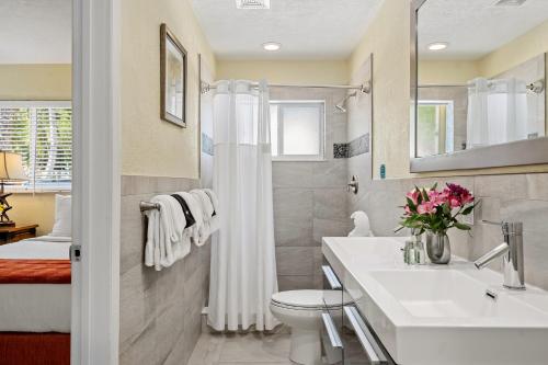 Baño blanco con lavabo y aseo en Coconut Bay Resort - Key Largo, en Cayo Largo