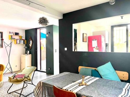 Cette chambre comprend un lit, des chaises et un miroir. dans l'établissement Maison au Vallon des Auffes Marseille, à Marseille