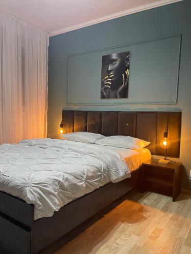 sypialnia z dużym łóżkiem i 2 lampami w obiekcie Home Comfort w Bukareszcie