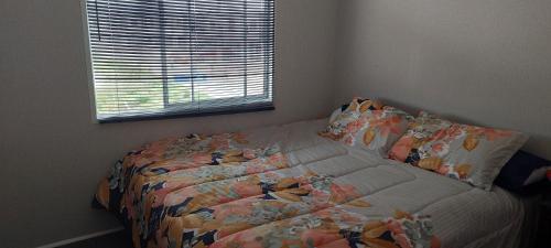 1 dormitorio con cama con edredón y ventana en Caleta san pedro, en La Serena
