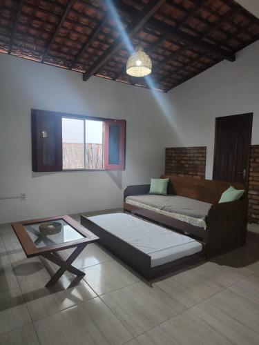 a living room with a bed and a table at Bons Aires in Atins