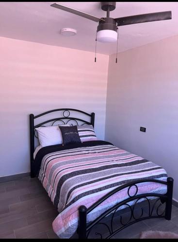 a bed in a room with a ceiling fan at HOTEL and Suites Cananea in Cananea