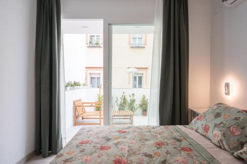 a bedroom with a bed and a large window at Casa Niña in Seville