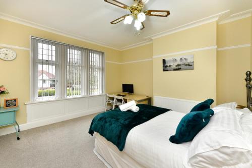 a bedroom with a bed and a ceiling fan at 5* Hotel Quality-10Min From City in Cardiff