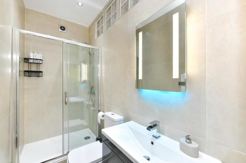 y baño con lavabo, ducha y aseo. en 5* Hotel Quality-10Min From City, en Cardiff