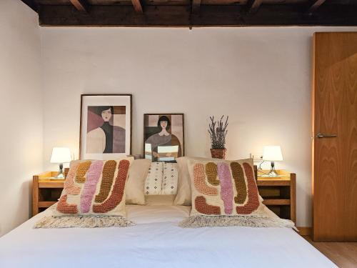 1 dormitorio con 1 cama con 2 cuadros en la pared en El Mirador del Naranco, en Oviedo