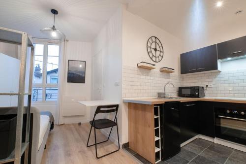 - une cuisine avec un bureau et un lit dans une chambre dans l'établissement Studio Cosy à 15min de Paris et 5min du Métro, à La Courneuve