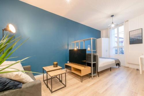 une chambre avec un lit et un mur bleu dans l'établissement Studio Cosy à 15min de Paris et 5min du Métro, à La Courneuve