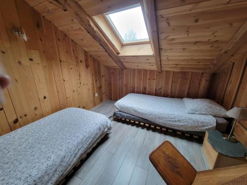 a bedroom with two beds in a wooden cabin at Magnifique Gite en Bord de Lac in Devesset