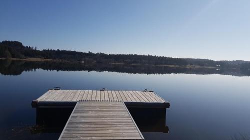 a dock in the middle of a lake at Magnifique Gite en Bord de Lac in Devesset