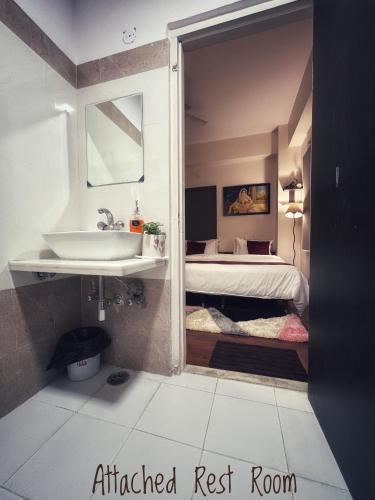 a bathroom with a sink and a bedroom with a bed at Elysium in Jaipur
