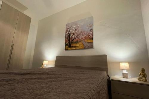 a bedroom with a bed and a painting on the wall at Igea Suite in Noto