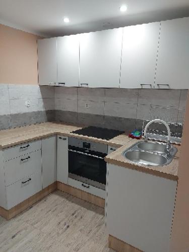 uma cozinha com armários brancos e um lavatório em DAR-KAJ 