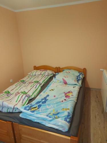 een bed met een dekbed in een slaapkamer bij DAR-KAJ 