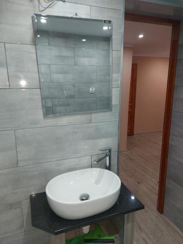 een badkamer met een witte wastafel en een spiegel bij DAR-KAJ 