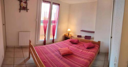 1 dormitorio con 1 cama con edredón rosa y ventana en Résidence Plage - 4 Pièces pour 7 Personnes 784, en Six-Fours-les-Plages