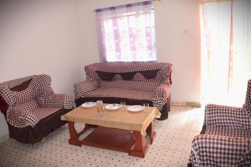 a living room with two chairs and a coffee table at Olgosua Homestay Maasai Mara in Sekenani