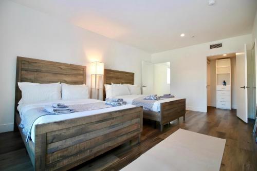 Los Angeles Premium 2BR&2BT Suites with Free Parking في لوس أنجلوس: غرفة نوم بسريرين و اللوح الأمامي خشبي كبير