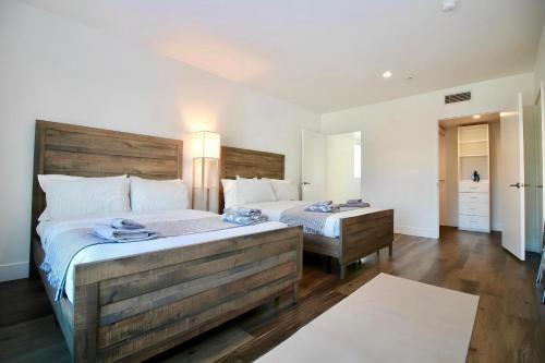 a bedroom with two beds and a large wooden headboard at Los Angeles Premium City Suites with Free Parking in Los Angeles