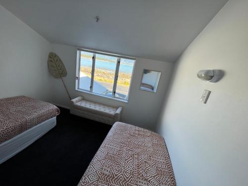 a small room with two beds and a window at Kaikoura Seaside lodge in Kaikoura