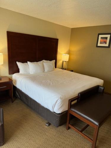 a hotel room with a large bed and a chair at Comfort Inn & Suites Lincoln City in Lincoln City
