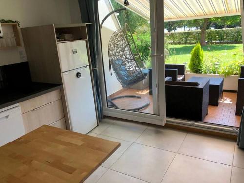 d'une cuisine avec une porte coulissante en verre s'ouvrant sur une terrasse. dans l'établissement Appartement : Aix les bains face au lac, à Aix-les-Bains