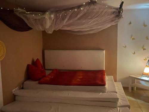 - une chambre avec un lit à baldaquin et des oreillers rouges dans l'établissement TantraXtreme, à Aguatona