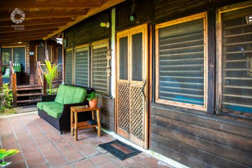 a green couch sitting on the porch of a house at Nirvana Resort in Lívingston