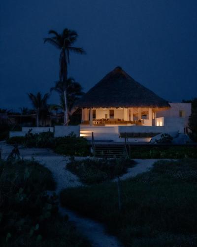a building with a thatched roof at night at Mazul Puerto Escondido in Tlachicón