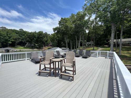 a wooden deck with chairs and a table on it at Wake N Lake in Littleton