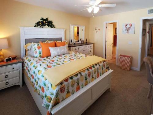 a bedroom with a large bed with orange pillows at Beachy Condo right on Oceanfront in Myrtle Beach