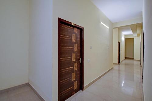 a wooden door in a room with a hallway at OYO Flagship Oblivion Stays in Bālihāti