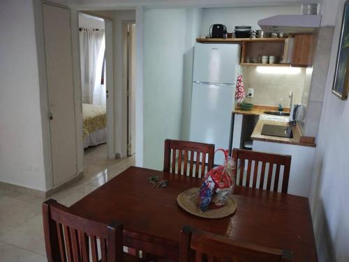 uma cozinha com uma mesa de madeira e uma cozinha com uma mesa; em Pinamar departamento 2 ambientes con vista al mar em Pinamar