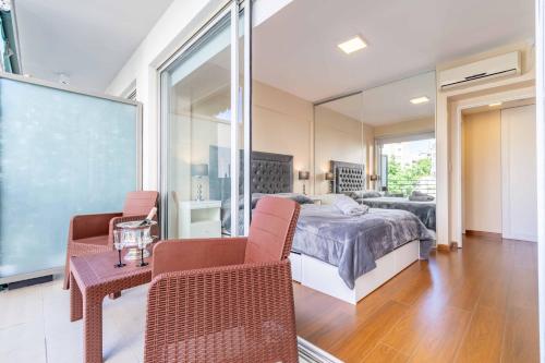 1 dormitorio con 1 cama, 2 sillas y espejo en Fine & Better located 4 people Apartment in Palermo, Buenos Aires en Buenos Aires