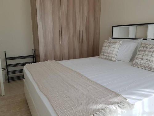 a bedroom with a large bed with white sheets and pillows at Cosy 1 bedroom in Damac Hills in Dubai