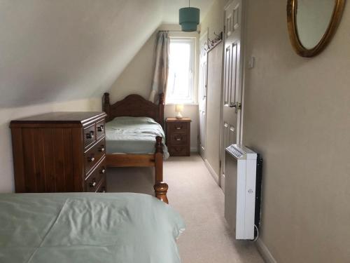 a bedroom with a bed and a dresser and a window at Cosy 3 Bed lodge on 35 acre Holiday Estate in Bodmin