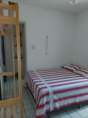 um quarto com uma cama com um cobertor listrado e uma escada em Hostel da Socorro em Recife