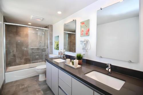 a bathroom with two sinks and a toilet and a shower at Los Angeles Premium City Suites with Free Parking in Los Angeles