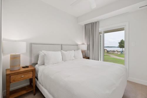 una camera bianca con un grande letto e una finestra di Touchstone Resort a Bracebridge