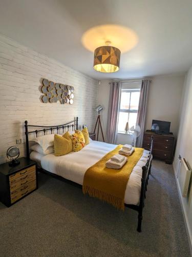 a bedroom with a large bed with yellow pillows at Russet Quarter, Parking subject to availability in York